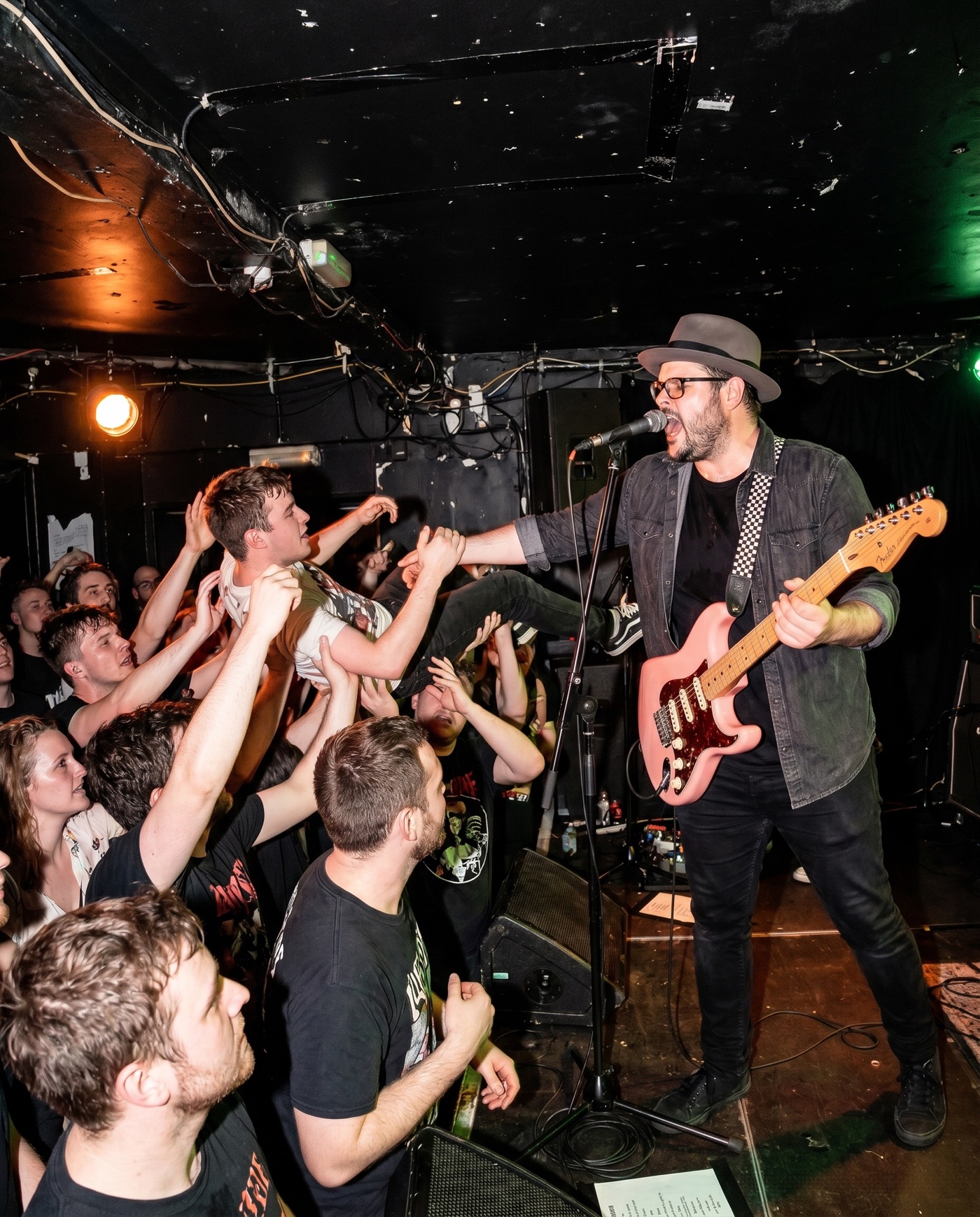 Grant Morriss performing guitar beside a crowd surfer